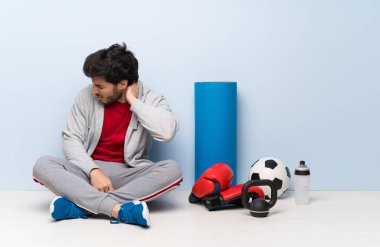 Boynu yarası ile yerde oturan spor adam