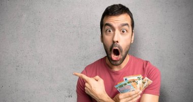Adam çok para alarak şaşırttı ve dokulu duvar üzerinde yan işaret