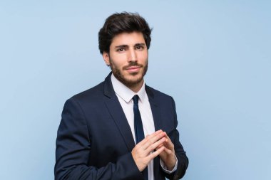 İzole mavi duvar üzerinde işadamı bir şey entrika