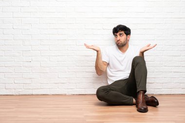 Genç adam el yetiştirirken şüpheleri olan yerde oturuyor