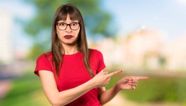 Gözlük ile kadın korkmuş ve açık havada yan işaret