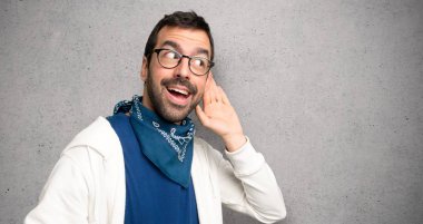 Gözlüklü bir şey el kulak dokulu duvar'ın üstüne koyarak dinleme yakışıklı adam