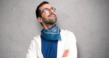 Gözlüklü dokulu duvar'ın üstüne gülümseyen ararken yakışıklı adam