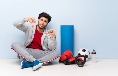 Spor adam başparmak aşağı gösteren katta oturan
