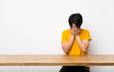 Yorgun ve hasta ifade ile sarı gömlek li Asyalı adam