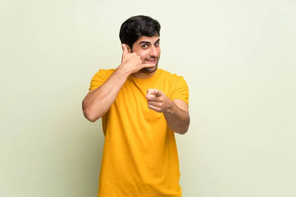 Jeune Homme Sur Mur Rose Faisant Geste Téléphone Pointant Vers — Photo