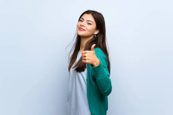 Teenager Mädchen Mit Erhobenem Daumen Über Blaue Wand Weil Etwas — Stockfoto