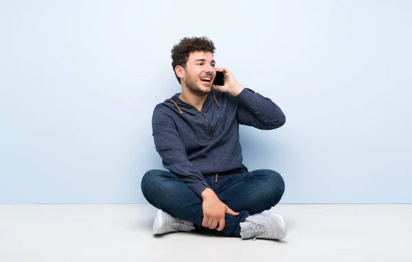 Młody Człowiek Siedzi Podłodze Rozmawia Przez Telefon Komórkowy — Zdjęcie stockowe