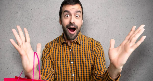Mann Mit Einkaufstüten Voller Überraschung Und Schockiertem Gesichtsausdruck Über Mauer — Stockfoto