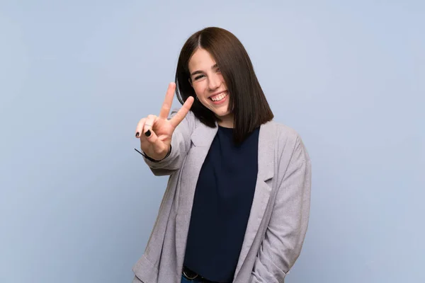 Young Woman Isolated Blue Wall Smiling Showing Victory Sign — Stock Photo, Image