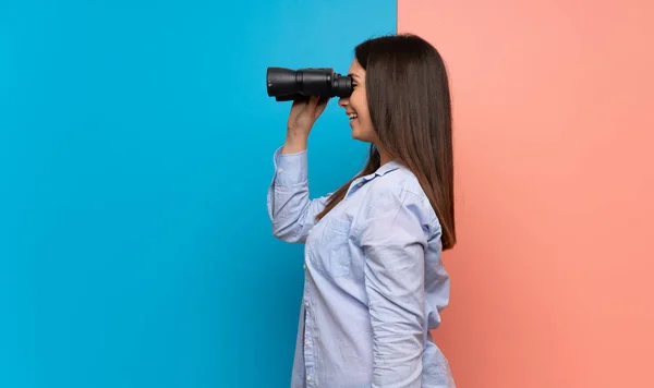 Mujer Joven Sobre Pared Rosa Azul Mirando Distancia Con Prismáticos —  Fotos de Stock