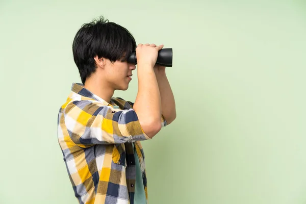 Hombre Asiático Sobre Pared Verde Aislada Con Binoculares Negros — Foto de Stock