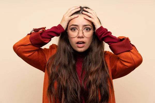 Teenager girl with coat with surprise facial expression