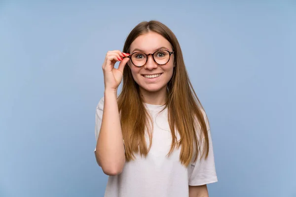 Jovem Mulher Sobre Parede Azul Com Óculos Surpreso — Fotografia de Stock