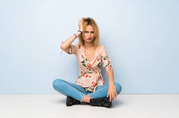 Junge Blonde Frau Sitzt Auf Dem Boden Mit Einem Ausdruck — Stockfoto