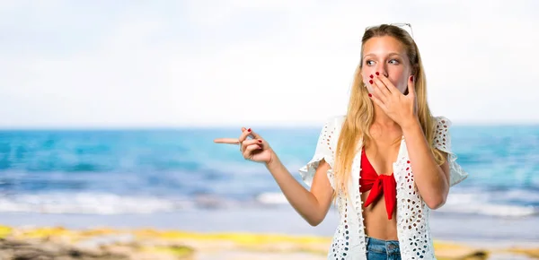 Chica rubia en vacaciones de verano señalando el dedo a un lado con — Foto de Stock