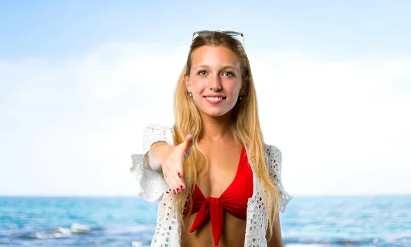 Blond meisje in zomer vakantie schudden handen voor het sluiten van een goede — Stockfoto