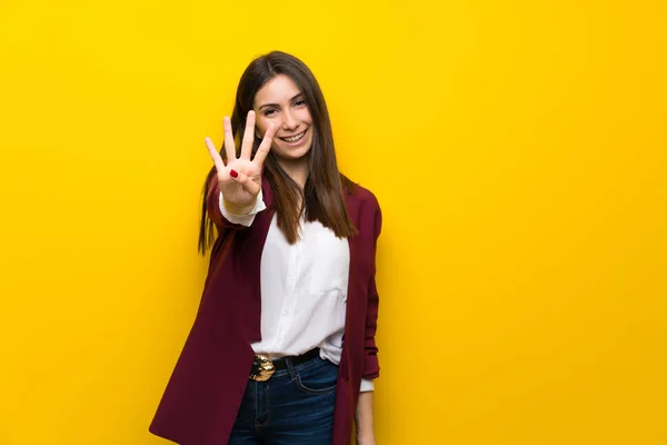 Młoda Kobieta Żółty Ścianę Szczęśliwy Liczenia Cztery Palcami — Zdjęcie stockowe