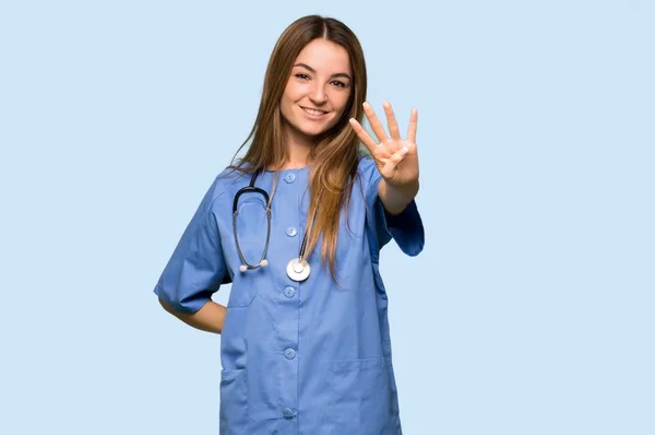 Jovem Enfermeira Feliz Contando Quatro Com Dedos Fundo Azul Isolado — Fotografia de Stock