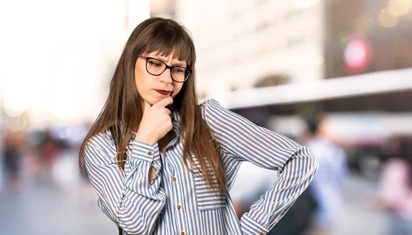 在户外思考的戴眼镜的妇女 — 图库照片