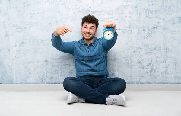 Jovem Sentado Chão Segurando Relógio Alarme Vintage — Fotografia de Stock