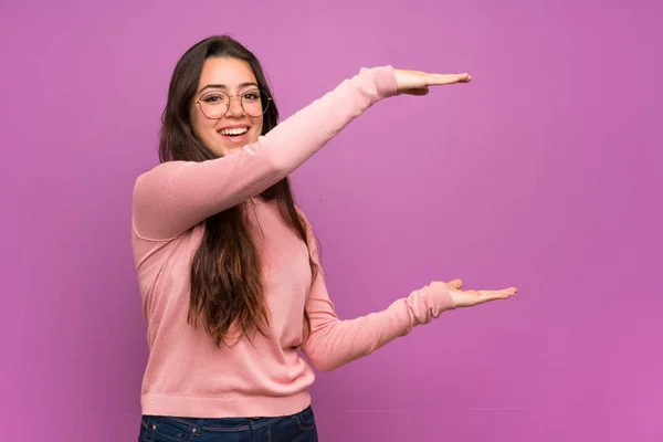 Menina Adolescente Sobre Parede Roxa Segurando Copyspace Para Inserir Anúncio — Fotografia de Stock