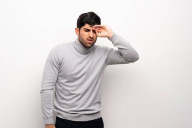 Yorgun ve hasta ifade ile izole beyaz duvar üzerinde genç adam