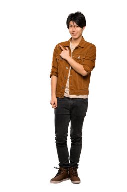 Izole beyaz arka plan üzerinde bir ürün sunmak için yan işaret kahverengi ceket ile Asyalı bir adam tam uzunlukta bir çekim