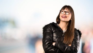 Açık havada gülümseirken gözlük ile kadın bakıyor