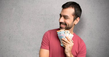 Adam dokulu duvar üzerinde çene üzerinde el ile yan bakarak çok para alıyor