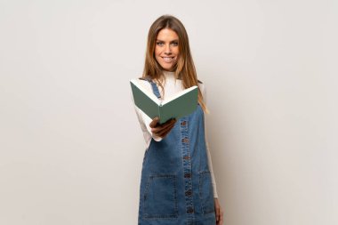 İzole beyaz duvar üzerinde güzel bir kadın bir kitap tutan ve birine veren