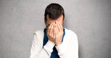 Dokulu duvar üzerinde yorgun ve hasta ifade ile gözlüklü yakışıklı adam