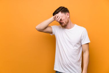 Yorgun ve hasta ifade ile kahverengi duvar üzerinde Redhead adam