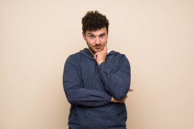 İzole duvar üzerinde kıvırcık saçlı adam ön bakıyor