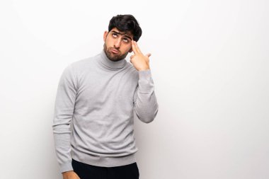 İntihar jesti yapmakta zorlanan, izole edilmiş beyaz duvarlı genç bir adam.