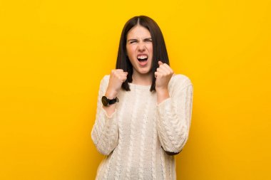 Izole sarı duvar üzerinde genç kadın kötü bir durum tarafından sinirli