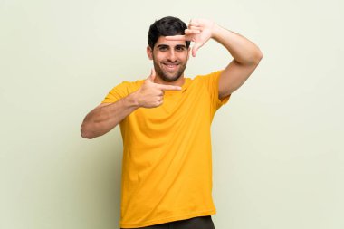 Pembe duvar yüz odaklanarak genç adam. Çerçeve sembolü