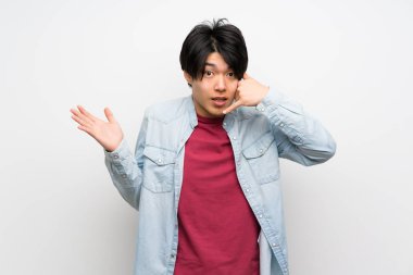 Izole beyaz arka plan üzerinde Asyalı adam telefon jest yapma ve şüphe