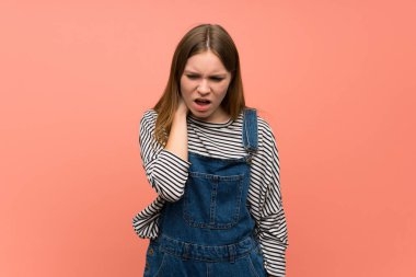 Pembe duvarın üstünde boynu ağrıyan genç bir kadın.