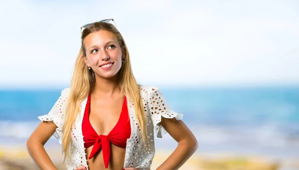 Chica rubia en vacaciones de verano posando con los brazos en la cadera y reír — Foto de Stock