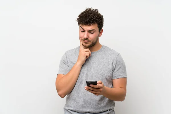 Mann Mit Lockigem Haar Über Abgelegene Mauer Mit Handy — Stockfoto