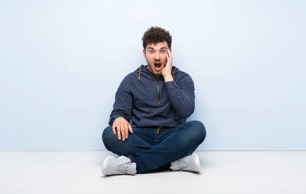 Junger Mann Sitzt Überrascht Und Schockiert Auf Dem Boden — Stockfoto