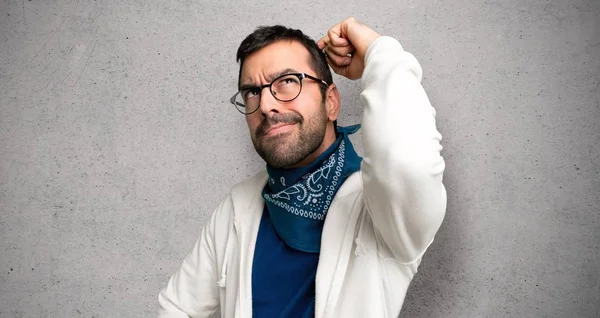 Jóképű Férfi Miközben Vakarja Fejét Texturált Falon Kétségek Szemüveg — Stock Fotó