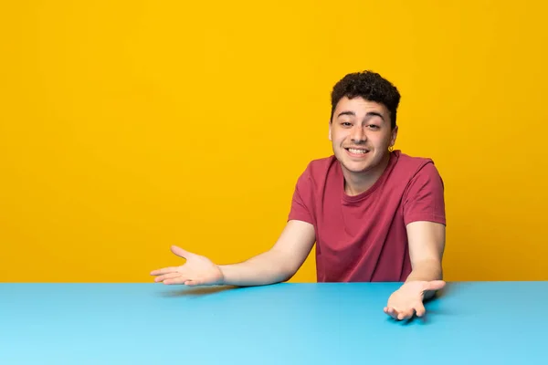 Renkli Duvarı Masası Olan Genç Adam Gülümsüyor — Stok fotoğraf