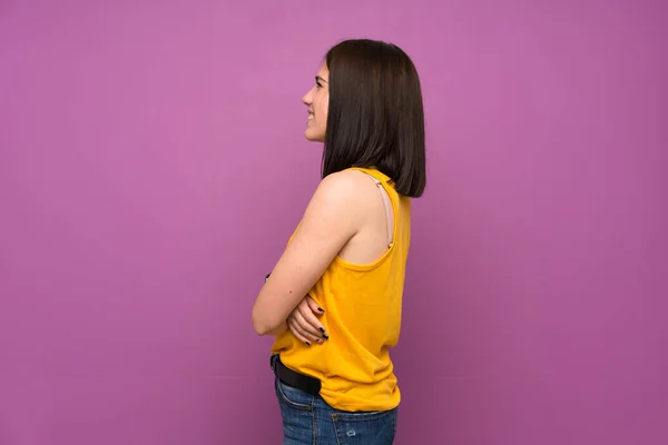 Jonge Vrouw Geïsoleerde Paarse Muur Laterale Positie — Stockfoto