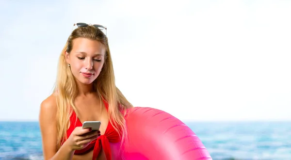 Mujer rubia en vacaciones de verano hablando con el móvil en la playa — Foto de Stock
