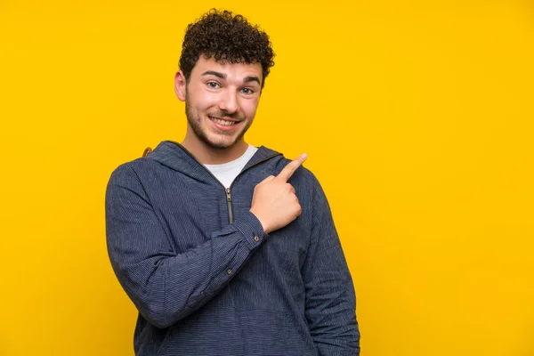 Giovane Oltre Isolato Muro Giallo Puntando Dito Verso Lato — Foto Stock