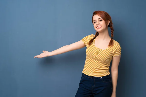 Young Redhead Woman Blue Background Pointing Back Presenting Product — Stock Photo, Image