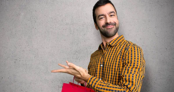 Hombre Con Bolsas Compras Presentando Una Idea Mientras Mira Sonriendo —  Fotos de Stock