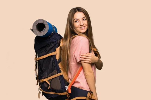 Młoda Backpacker Kobieta Patrząc Przez Ramię Uśmiechem Odizolowanym Żółtym Tle — Zdjęcie stockowe